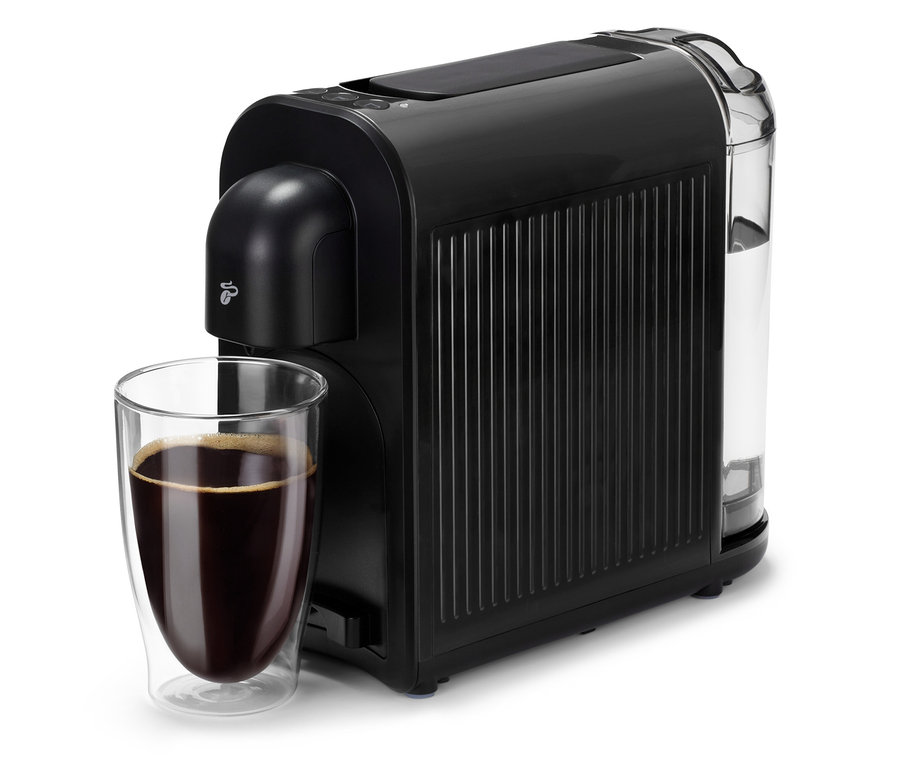 Eine schwarze Cafissimo now black Kaffeemaschine neben einem Glas mit Kaffee.