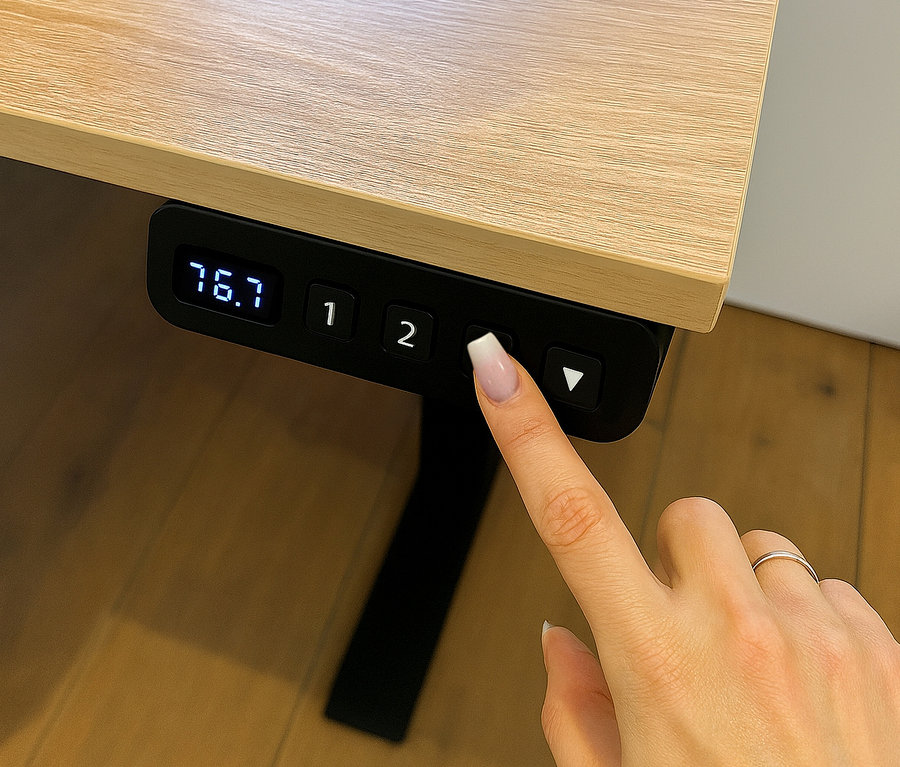 Eine Hand drückt die Taste zum Verstellen eines elektrischen Schreibtischs »Emmik L138« in Weißeiche.