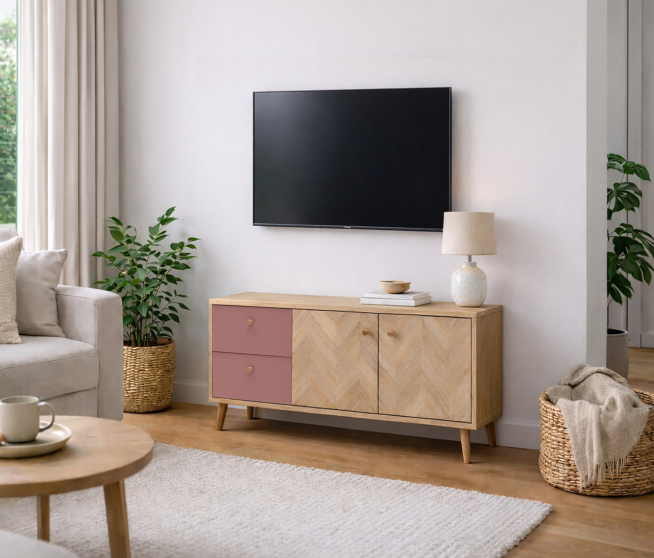 Wohnzimmer mit Fernseher an der Wand über einem Holzschrank mit rosa Schubladen, Lampe, Pflanze und Korb.