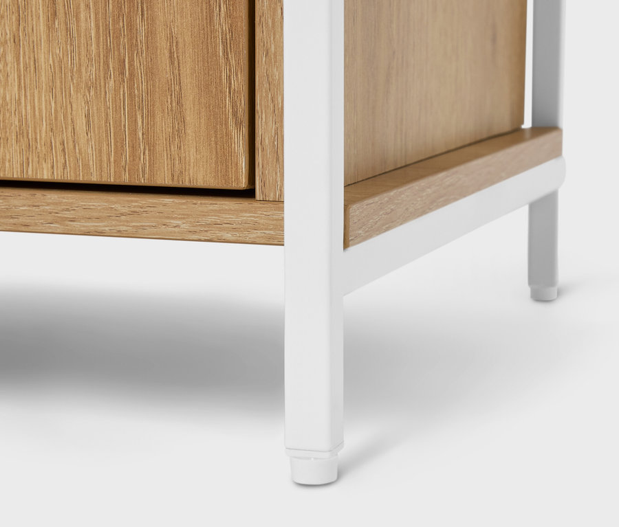 Detailansicht eines Holzschranks mit weißem Metallgestell.