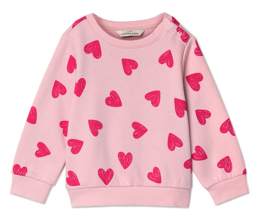 Ein hellrosa Pullover mit rotem Herzmuster liegt flach auf einer weißen Oberfläche.