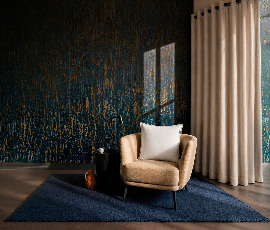 Ein beiger Sessel mit einem offwhite SCHÖNER WOHNEN-Kollektion Dekokissen-Bezug »COAST« steht auf einem dunkelblauen Teppich. Daneben ein schwarzer Beistelltisch und eine orangefarbene Kanne. Die Wand ist mit einer dunkelblauen Tapete mit goldenen Akzenten versehen, rechts hängt ein beiger Vorhang.