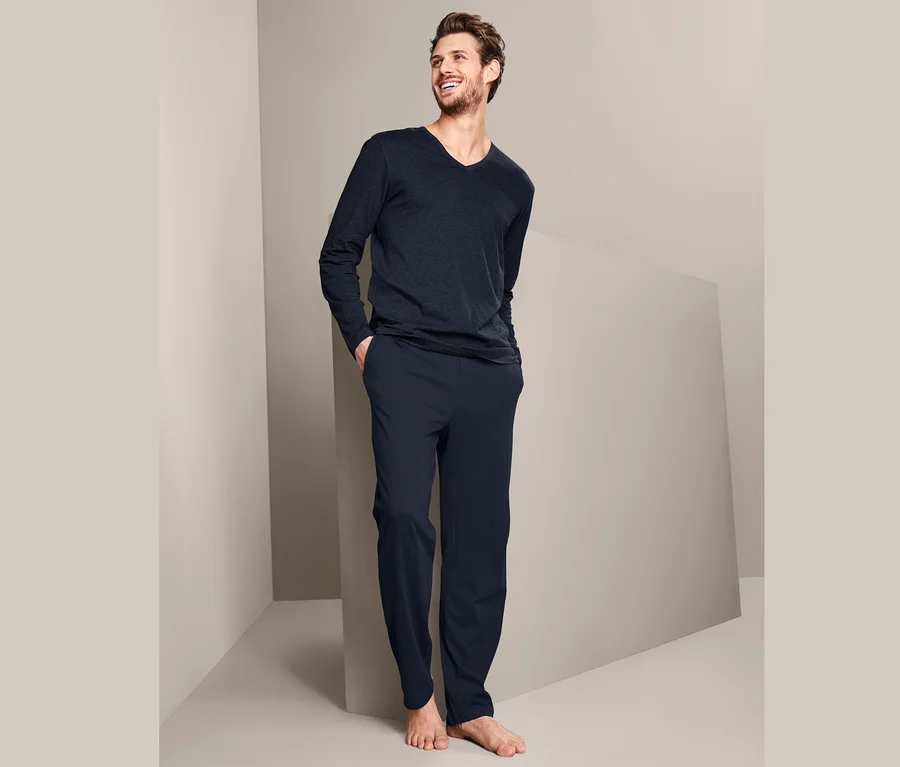 Mann trägt einen Pyjama und lächelt.