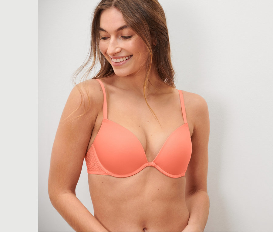 Lächelnde Frau trägt einen Push-up-BH mit Spitze.