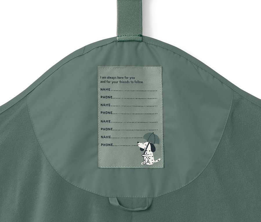 Detailaufnahme einer Kinder-Thermo-Regenhose in Dunkelgrün mit Etikett für Name und Telefonnummer.