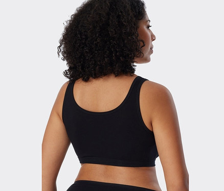 Rückansicht einer Frau mit dunklem Haar, die einen schwarzen 2 SCHIESSER Bustiers mit Bio-Baumwolle trägt.