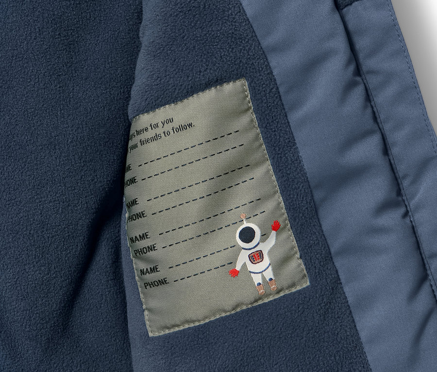 Detailaufnahme eines Kinder-Schneekombis mit Innentasche und Namensschild.