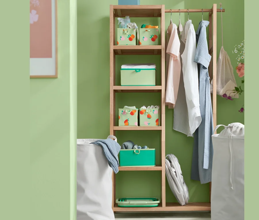 Ein Holzregal mit Wäschesammlern, einem faltbaren Wäsche-und-Spülkorb und Schubladen-Ordnungsboxen.