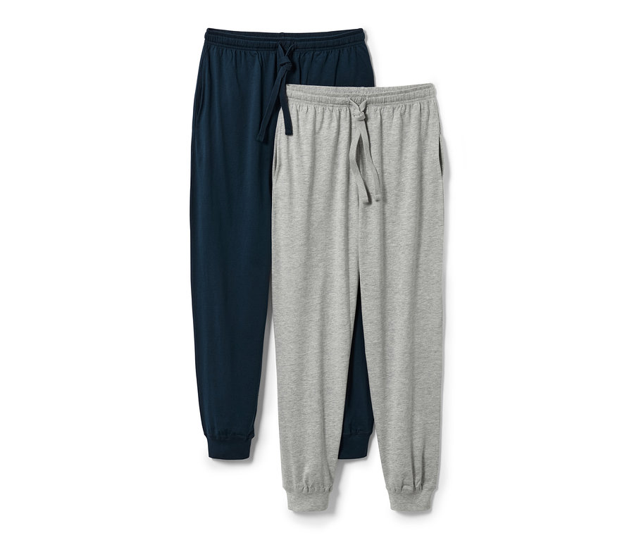 Zwei Pyjamahosen, eine marineblau, eine grau, liegen übereinander.