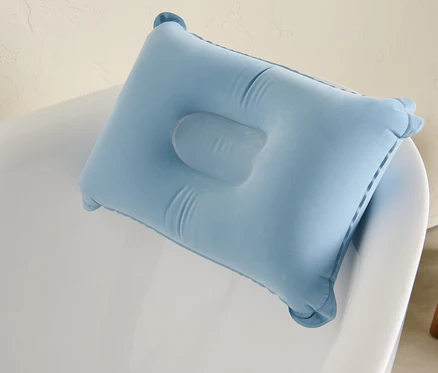 Blaues Badewannenkissen auf einer weißen Badewanne.