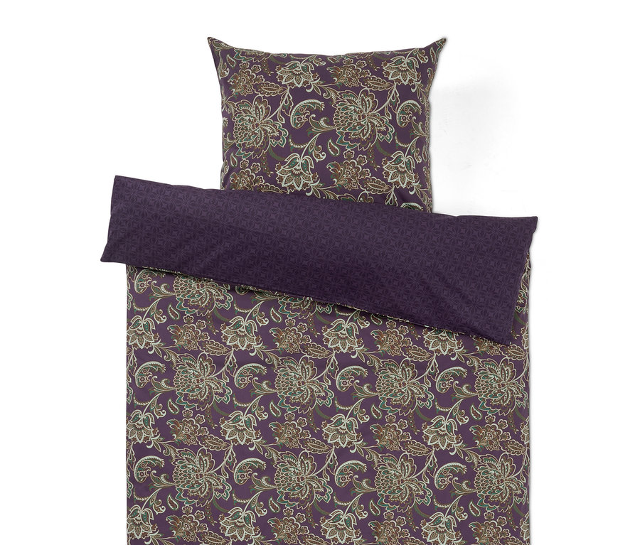 Lila Bettwäsche mit Blumenmuster und unifarbenem lila Kissenbezug.