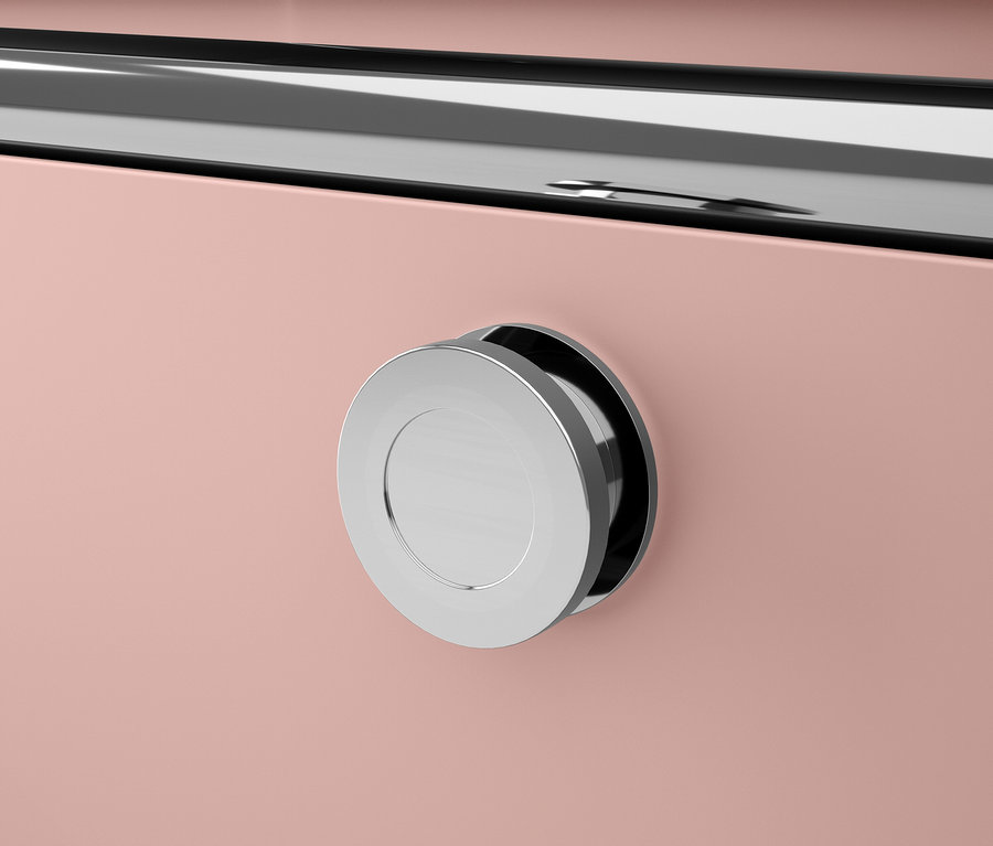 Detailaufnahme eines rosafarbenen Schranks mit einem runden silbernen Griff.