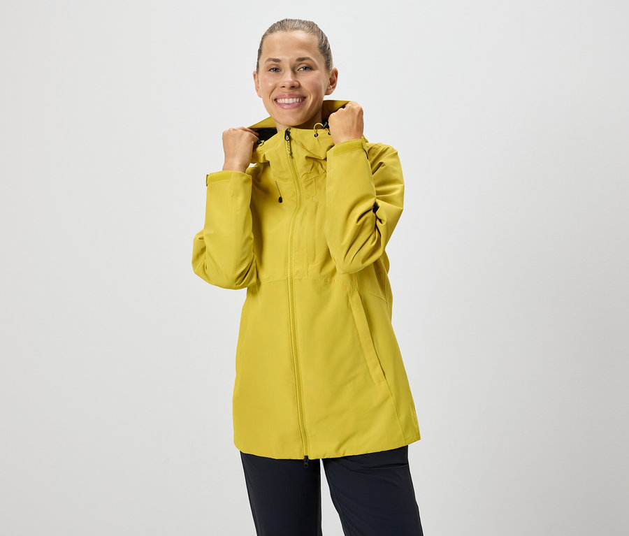 Frau richtet Kapuze von gelber Reissverschlussjacke.