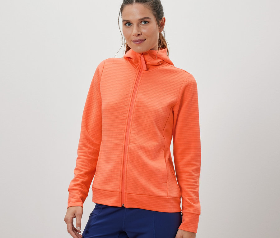 Frau trägt eine orange Funktionsjacke.