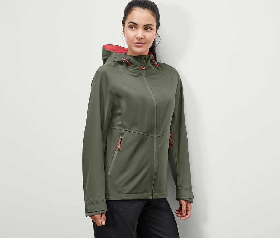 Frau trägt eine grüne 3-Lagen-Outdoorjacke.