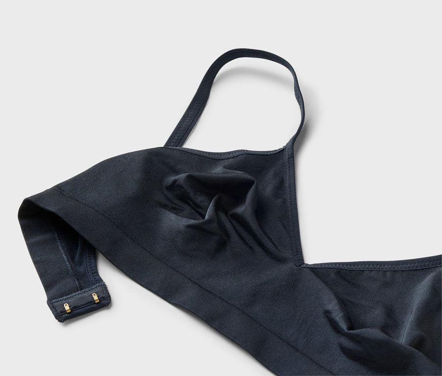 Nahaufnahme eines marineblauen BHs mit einem einzelnen Träger und goldenen Haken.