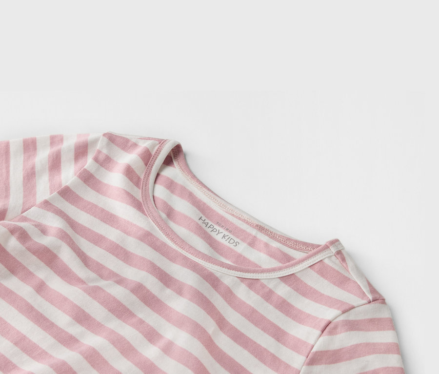 Nahaufnahme eines gestreiften, rosa-weißen T-Shirts mit der Aufschrift "HAPPY KIDS" am Kragen.