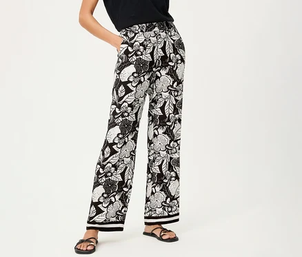 Frau mit Olsen Wide Leg Hose mit Blumenmuster und schwarzen Sandalen.