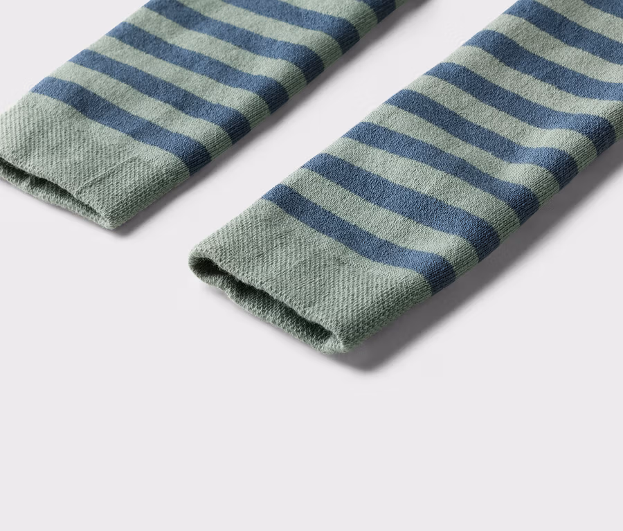 Nahaufnahme von zwei geringelten Socken in Grün und Blau auf einem weißen Hintergrund.
