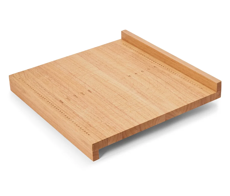 Quadratisches, hellbraunes Schneidebrett aus Holz mit Zentimeter- und Zollangaben auf der Oberfläche.