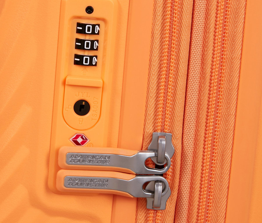 Nahaufnahme eines orangefarbenen American Tourister Koffers mit Zahlenschloss und Reißverschluss.