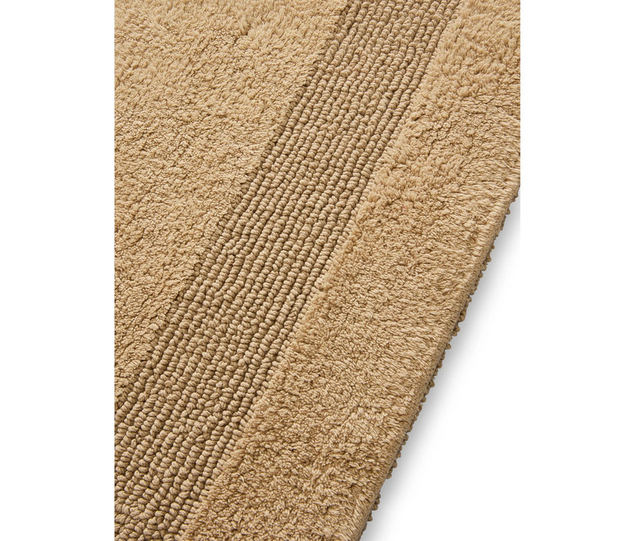 Beiger Badteppich mit einer gerippten Textur in der Mitte und flauschigeren Rändern.