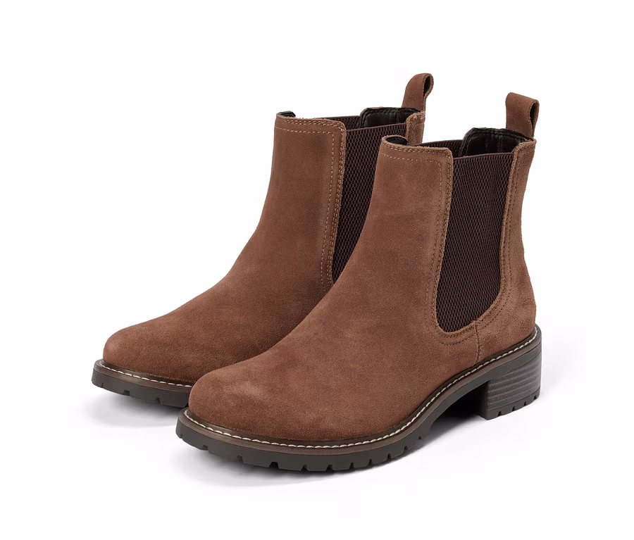 Ein Paar braune Chelsea-Boots aus Wildleder mit dunklen elastischen Seiteneinsätzen, Zugschlaufen und klobigen dunklen Sohlen mit hellen Nähten.