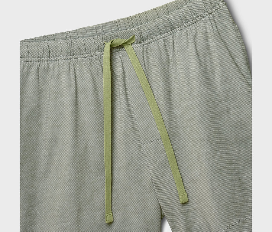 Nahaufnahme einer grün-weiß gestreiften Shorty-Pyjamahose mit elastischem Bund und hellgrünem Kordelzug.