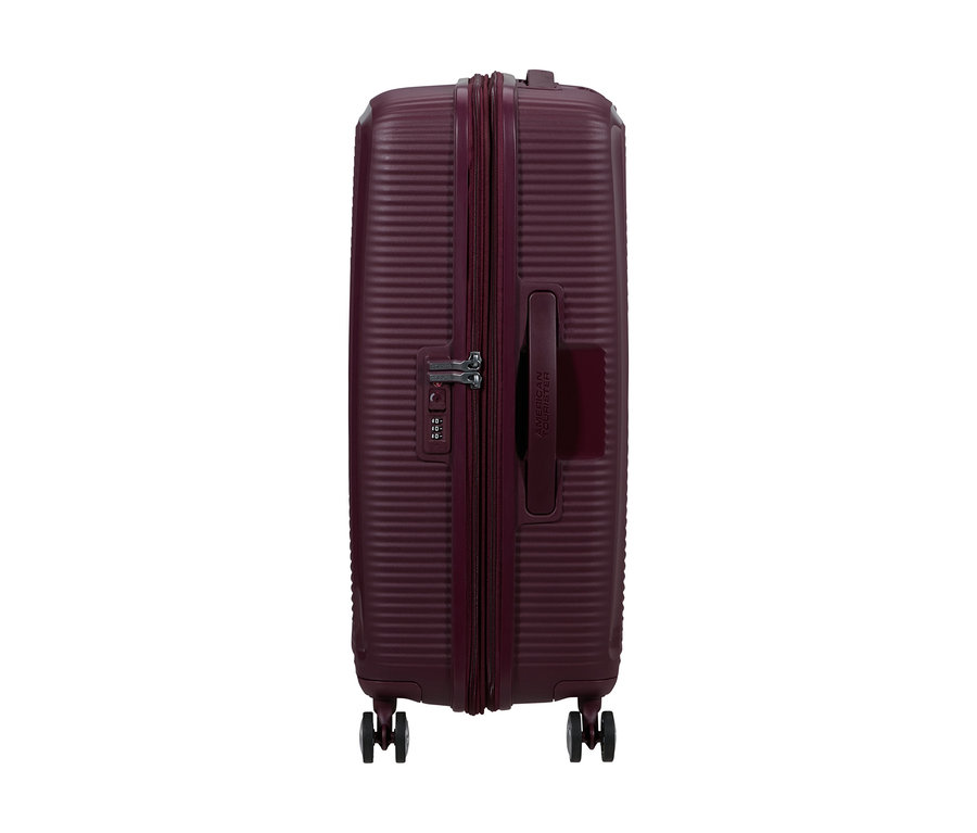 Mittelgroßer American Tourister Soundbox Spinner Hartschalenkoffer in Wildkirschrot, von der Seite gezeigt, mit Reißverschluss, Zahlenschloss und vier Rollen.