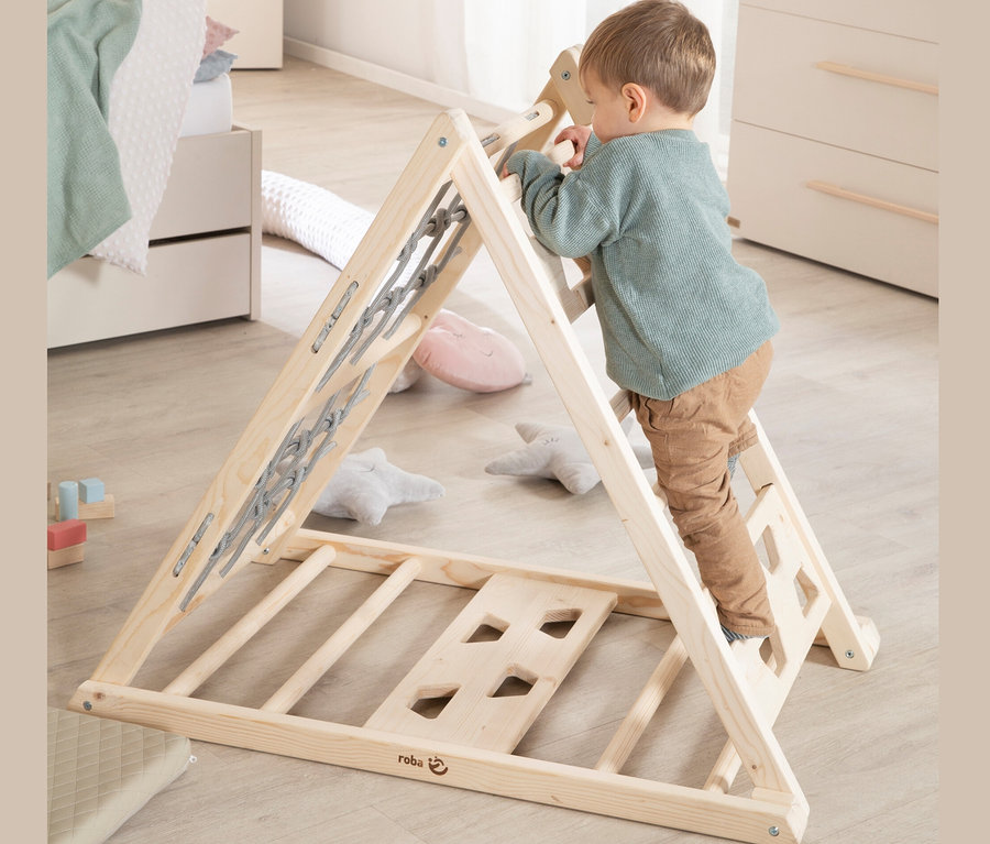Junge klettert auf roba Kletterdreieck im Kinderzimmer.