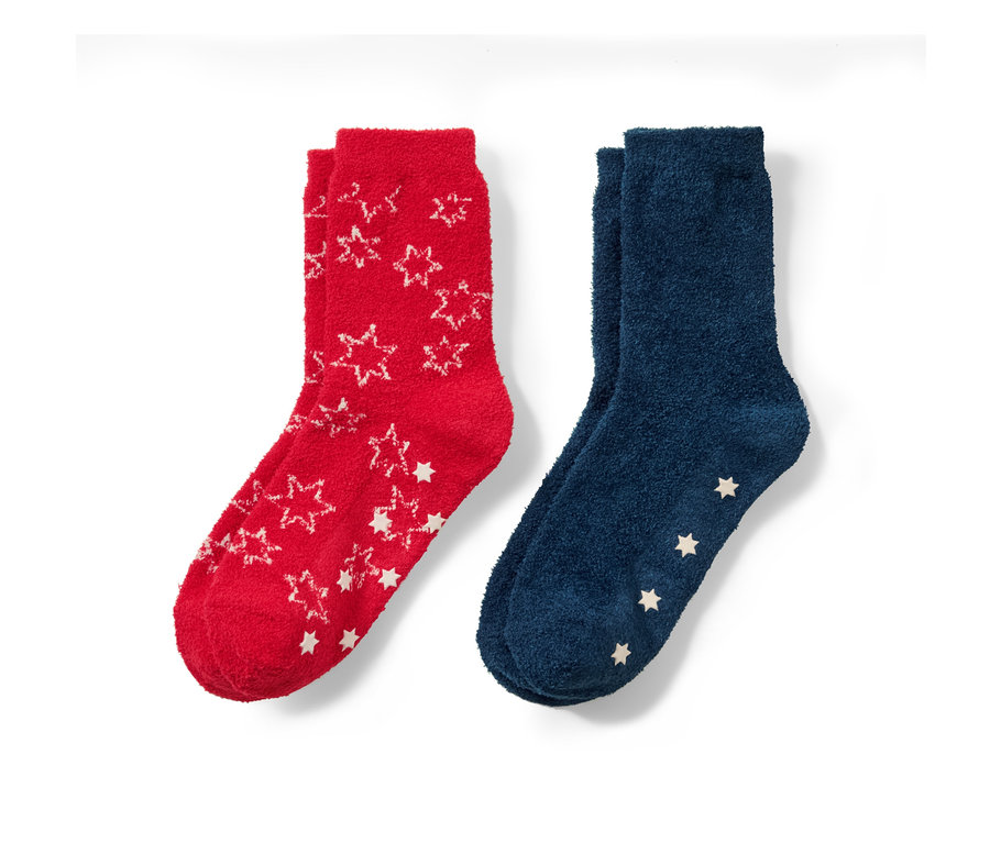 Zwei Paar Kinder-Kuschelsocken: ein Paar rot mit weißen Sternen, ein Paar blau mit weißen Sternen.