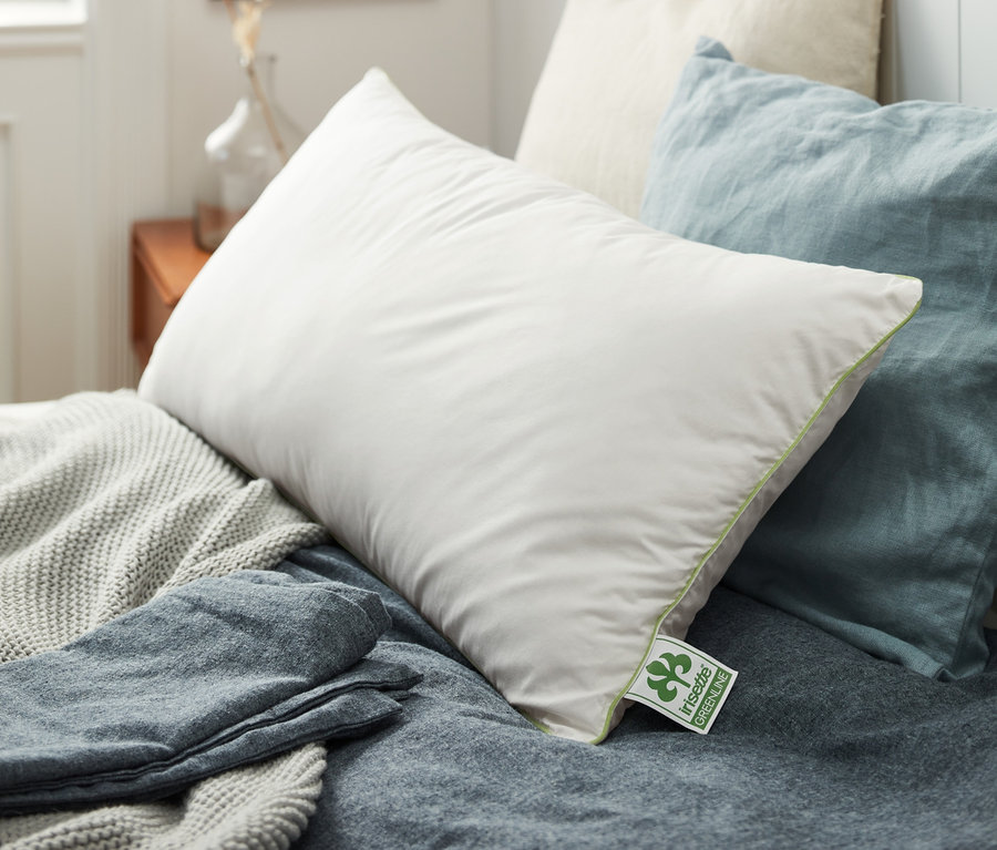 Auf einem Bett liegen mehrere irisette® greenline Kopfkissen in verschiedenen Größen.