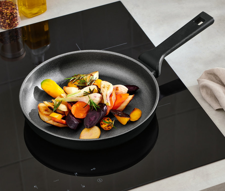 Gemüse wird in einer ca. 24 cm großen Profi-Aluminium-Pfanne gebraten.