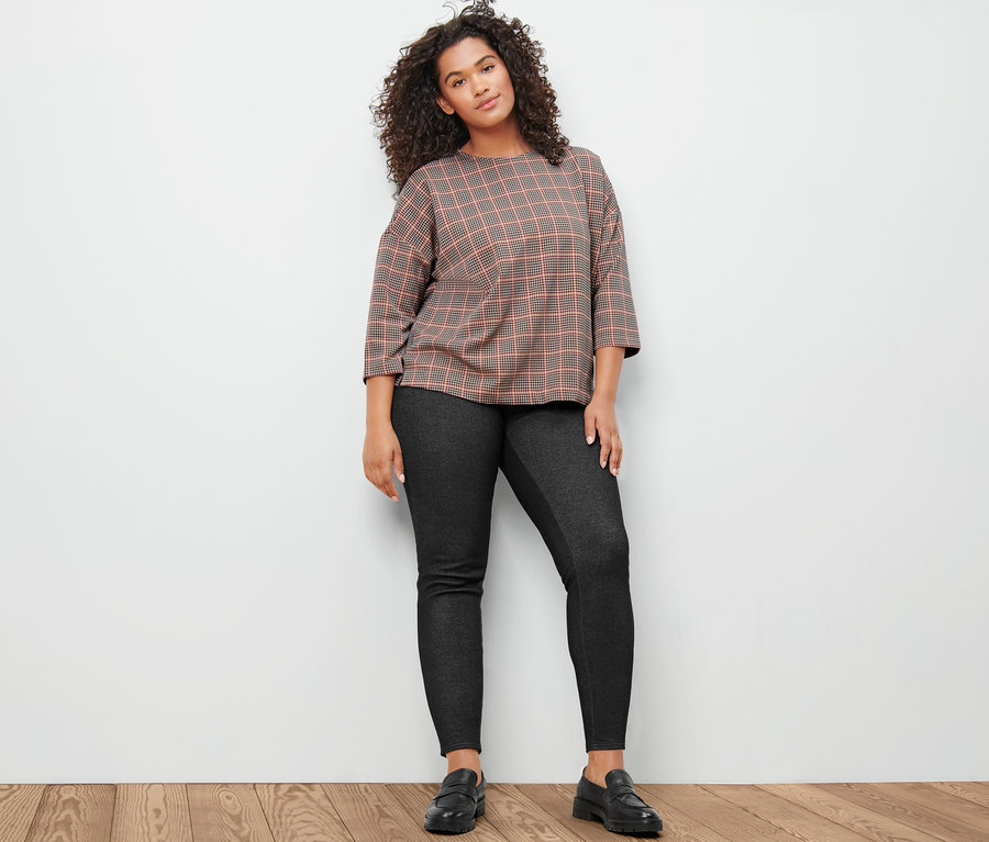 Frau posiert in Sweatshirt mit 3/4-Arm, Hahnentritt und gefütterten Leggings in Jeansoptik.