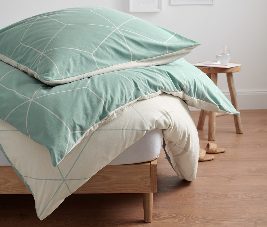 Winterjersey-Bettwäsche mit geometrischem Muster auf dem Bett.