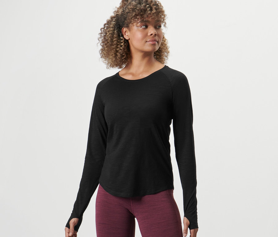 Frau posiert in einem Langarm-Sportshirt.