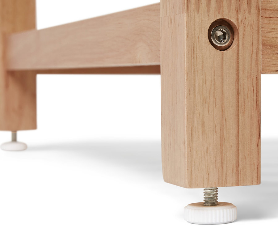 Detail einer Ecke eines Massivholzregals mit verstellbarem Fuß.