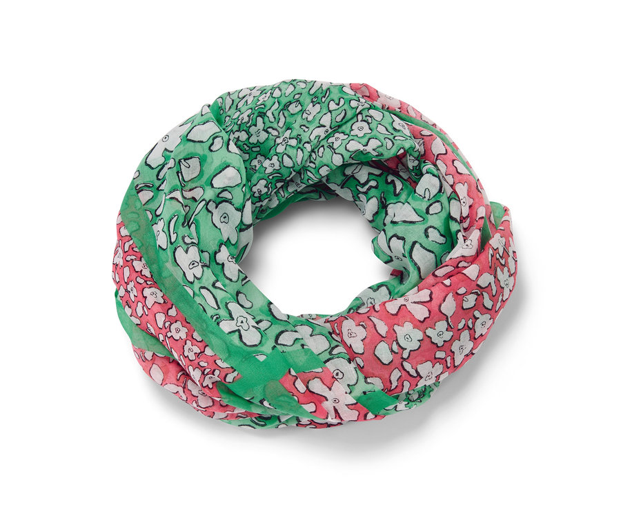 Ein bedruckter Loop-Schal in Grün, Rosa und Weiss liegt.