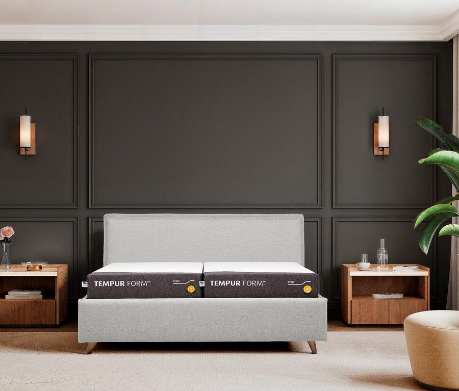 Zwei graue Tempur Form Matratzen auf einem Bett in einem Schlafzimmer.