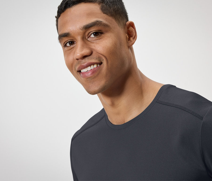 Porträt eines lächelnden Mannes in einem schwarzen T-Shirt.