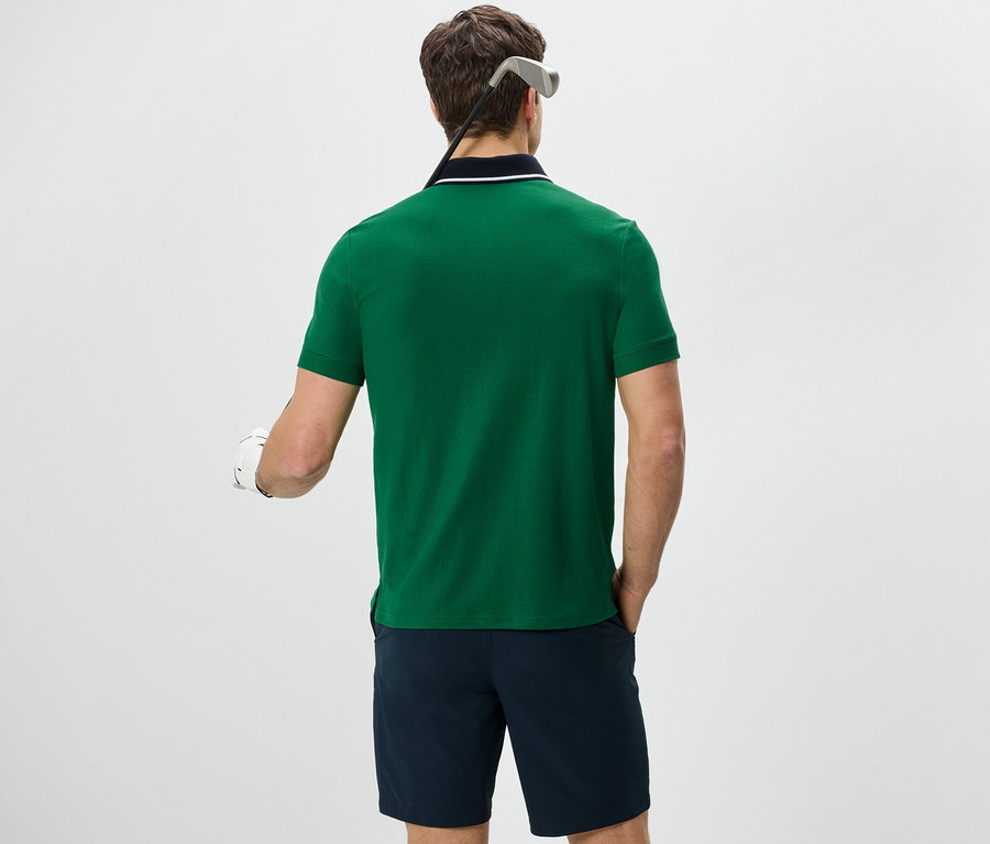Mann von hinten mit grünem Funktions-Poloshirt und dunkelblauen Shorts.