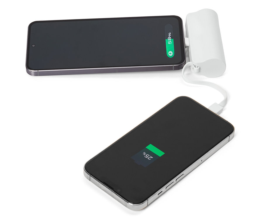 Zwei Smartphones, von denen eines mit einem weißen tragbaren Ladegerät verbunden ist, liegen auf einer weißen Oberfläche.