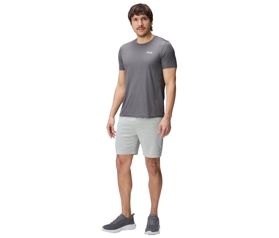 Mann in grauer Fila-Sportbekleidung, bestehend aus T-Shirt, Shorts und Turnschuhen.