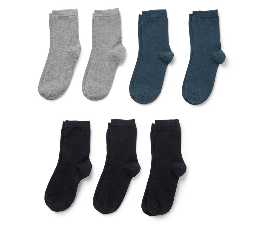 Drei Paar Socken in Grau, Dunkelblau und Schwarz liegen auf einem weißen Hintergrund.