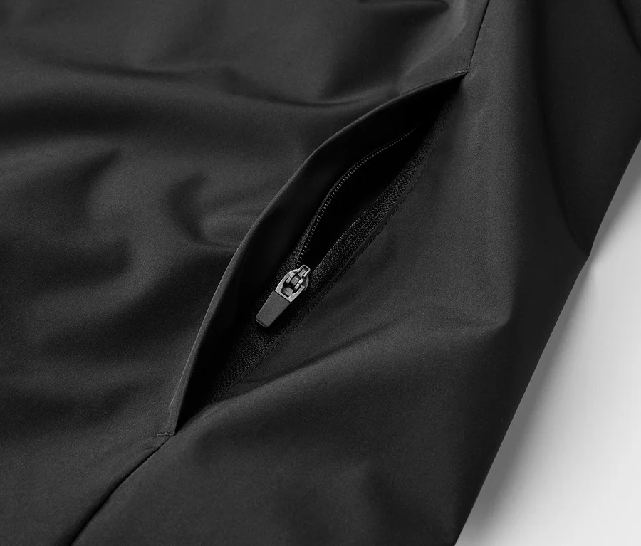 Nahaufnahme einer schwarzen Jacke mit Reißverschlusstasche.