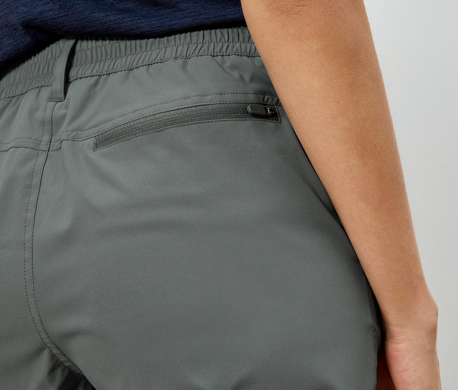 Nahaufnahme der Rückseite einer grauen Hose mit Reißverschlusstasche.