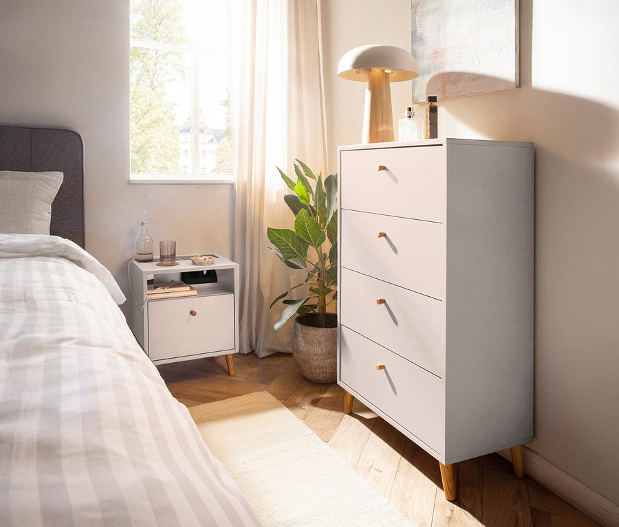 Schlafzimmer mit Kommode »Bjarne« in mattem Weiß, Nachttisch, Bett und Zimmerpflanze.