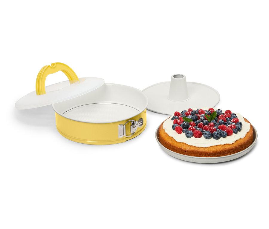 Gelbe Springform mit Deckel und Kuchen mit Beeren.