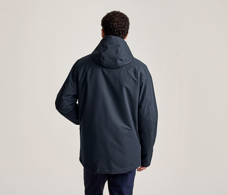 Mann von hinten in einer dunkelblauen Kapuzenjacke und dunklen Hosen.