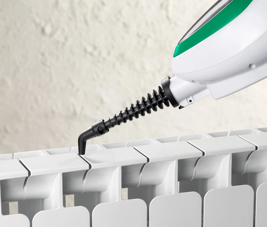Detail eines Multifunktionalen Dampfbesens beim Reinigen eines Heizkörpers.